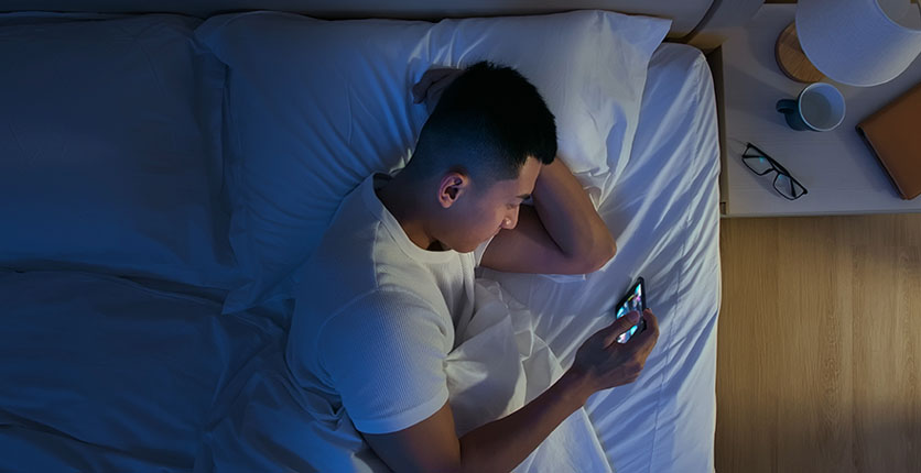 man using mobile in bed