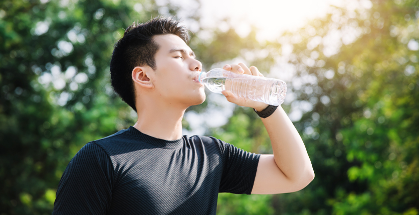 Man drinking from a bottle of water in the sun