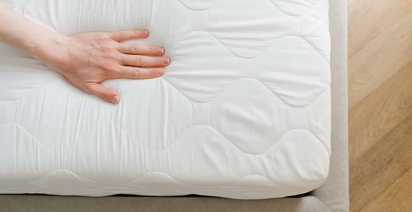 A hand testing a mattress