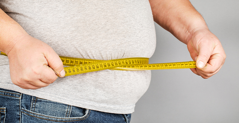 Man measuring waist with measuring tape