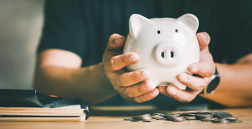 Close up of hands holding a piggy bank