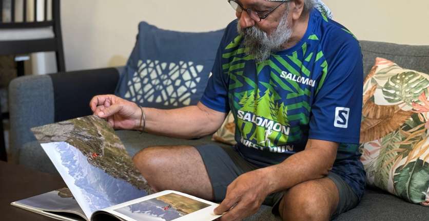 Salwant Singh looking at picture book of his past adventures